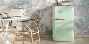 Frigorifero Smeg verde pastello in cucina elegante con tavolo bianco e tostapane coordinato