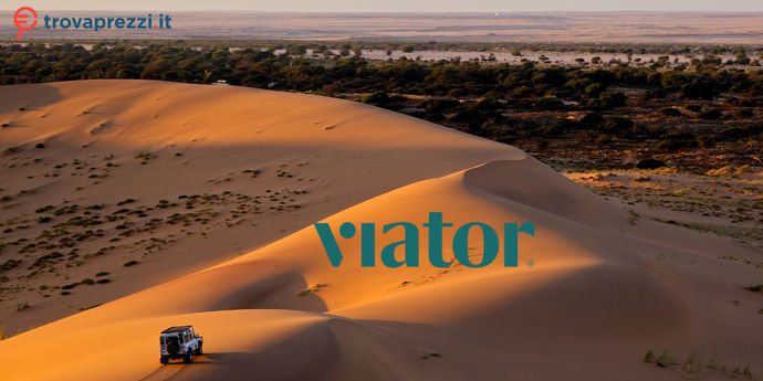Fuoristrada percorre dune di sabbia dorata al tramonto, con una distesa di alberi e deserto all’orizzonte