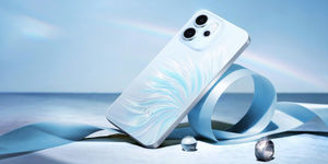 Smartphone Oppo Reno14 Fs con scocca bianca e motivo azzurro posato su superficie riflettente con nastro decorativo