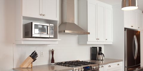 Cucina moderna con una delle migliori cappe aspiranti da cucina in acciaio, posizionata sopra i fornelli centrali.
