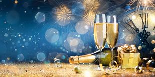 Calici di spumante, bottiglia e fuochi d’artificio, immagine sui migliori champagne per Capodanno