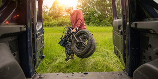 Uomo che carica una bici elettrica pieghevole all'interno di un furgoncino